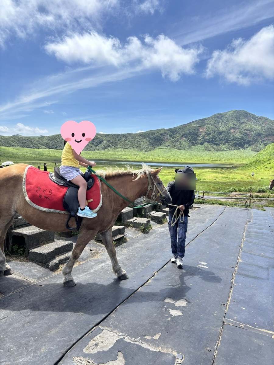 草千里ヶ浜で乗馬体験をする娘