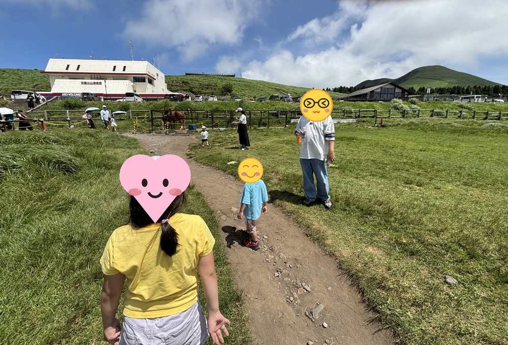 草千里ヶ浜の遊歩道を歩く家族